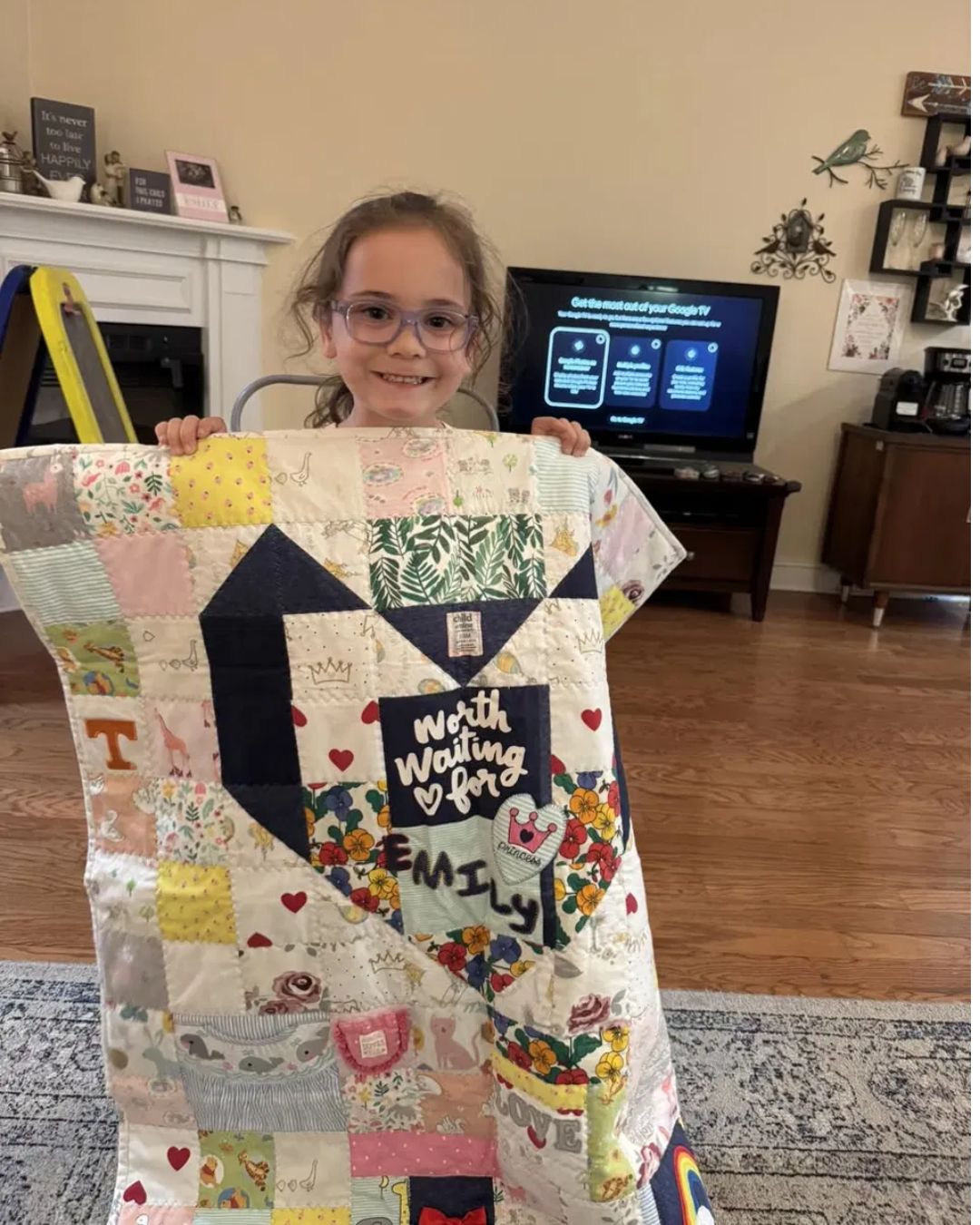 Emily holding the heart memory quilt made from her baby clothing